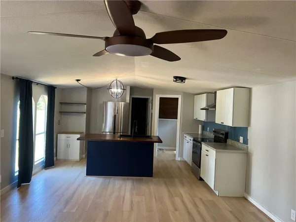 a kitchen with stainless steel appliances kitchen island granite countertop a refrigerator and a stove top oven