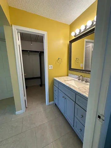 a bathroom with a granite countertop sink mirror and toilet