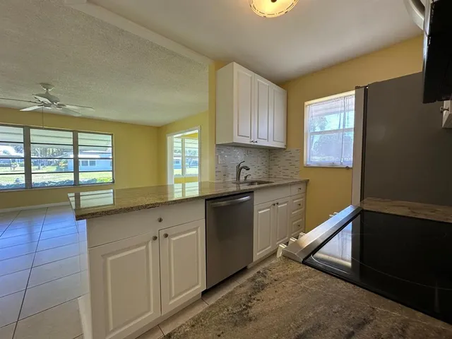 a kitchen with granite countertop white cabinets and white appliances