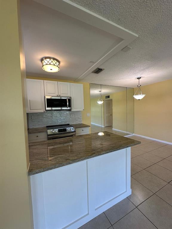 665 High Point Drive Delray Beach, FL 33445 - Photo 8 of 22 a kitchen with stainless steel appliances granite countertop a sink a stove cabinets and entryway