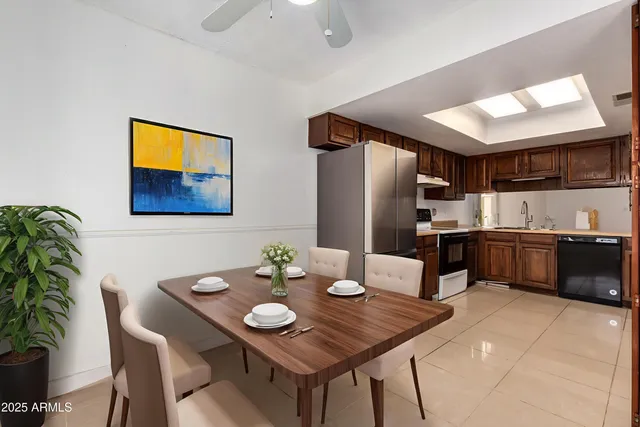 a kitchen with stainless steel appliances kitchen island granite countertop a table chairs and a refrigerator