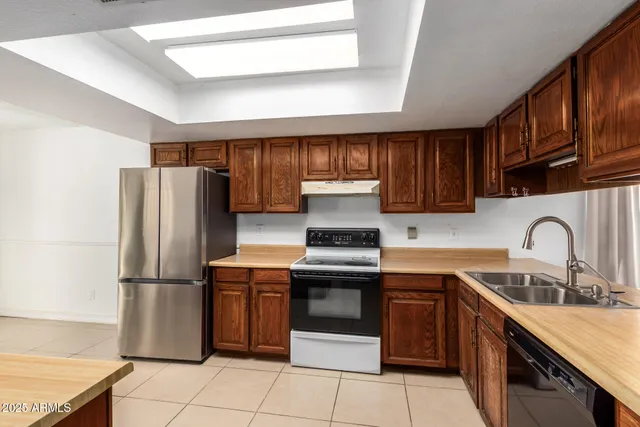 a kitchen with stainless steel appliances granite countertop a refrigerator stove and sink