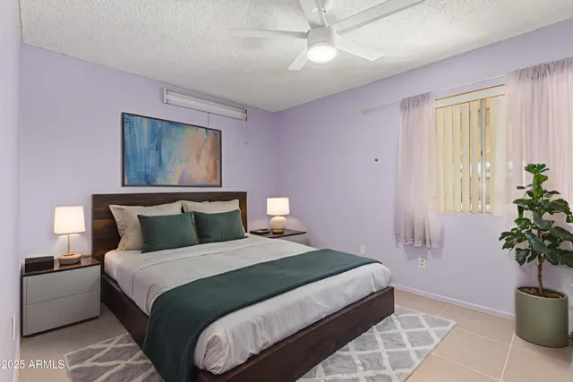 a bedroom with a large bed and a potted plant