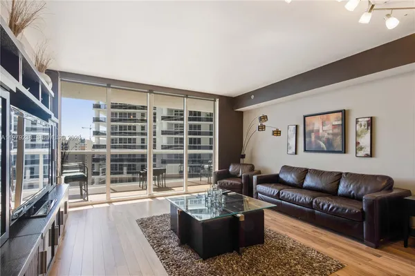 a living room with furniture windows and a flat screen tv