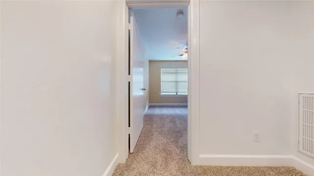 en empty room with windows and ceiling fan