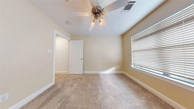 a view of an empty room and chandelier fan