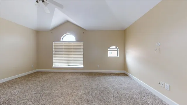 an empty room with a window and a ceiling fan
