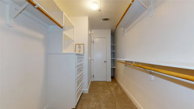 a view of walk in closet with empty racks