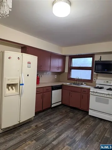 a kitchen with granite countertop a refrigerator stove top oven and sink