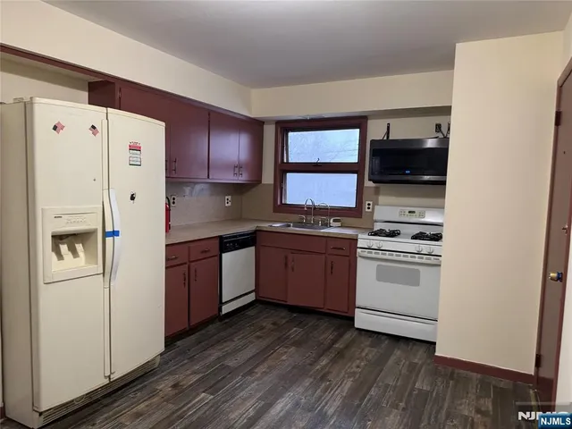 a kitchen with a refrigerator and a stove top oven