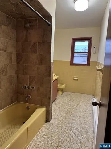 a bathroom with a tub a toilet and a shower