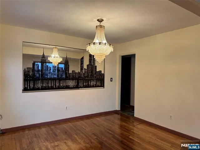 a view of a room with wooden floor and chandelier