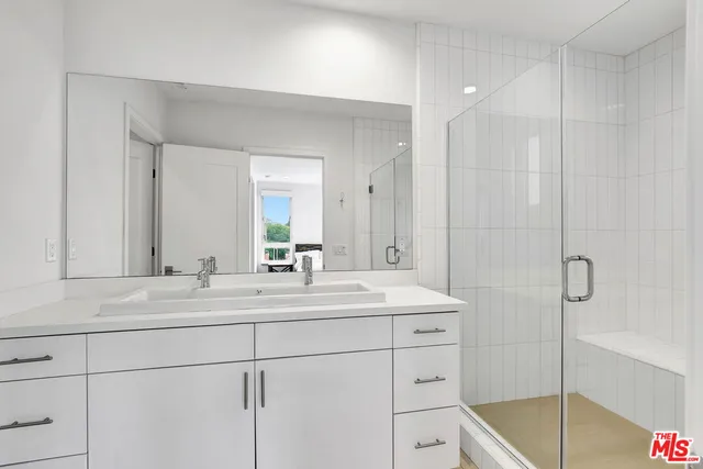 a bathroom with a double vanity sink mirror and shower