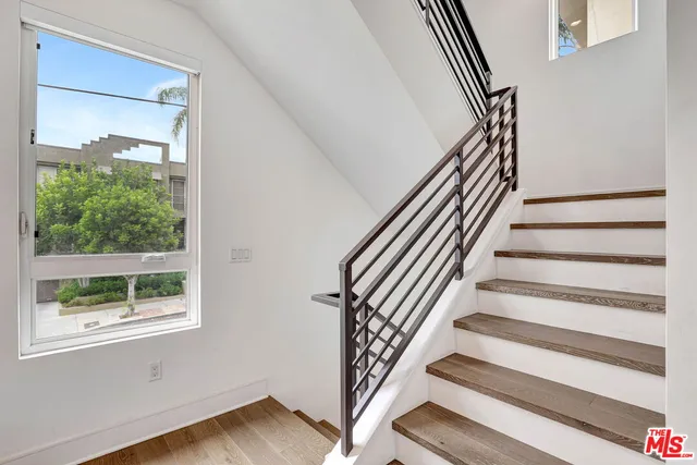 a view of staircase with wooden floor and white walls