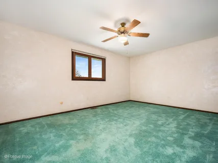 a view of a big room with wooden floor and windows