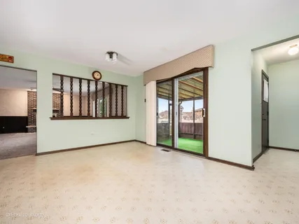 a view of an empty room with a window and bathroom