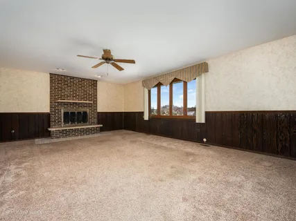 a view of an empty room with a fireplace and a window