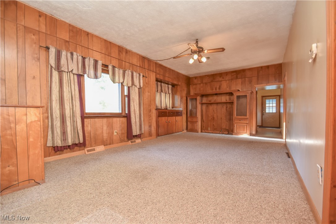 5382 West Webb Road Youngstown, OH 44515 - Photo 43 of 50 Carpeted empty room with a textured ceiling, wooden walls, and ceiling fan
