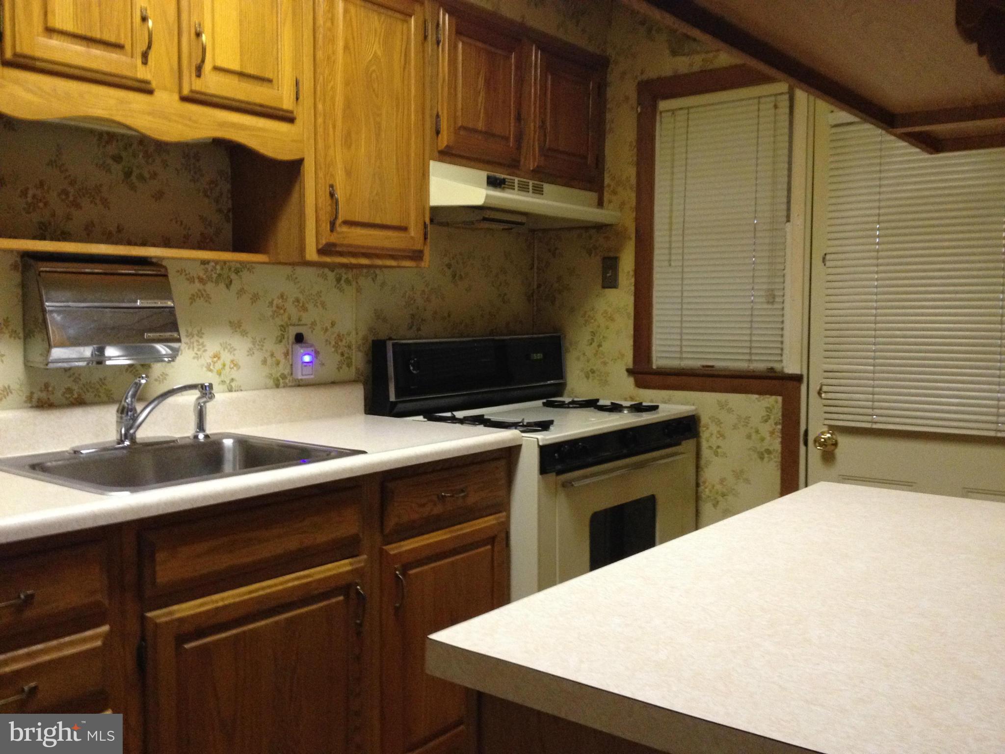 455 Torner Road Baltimore, MD 21221 - Photo 13 of 30 a kitchen with a sink a stove and cabinets