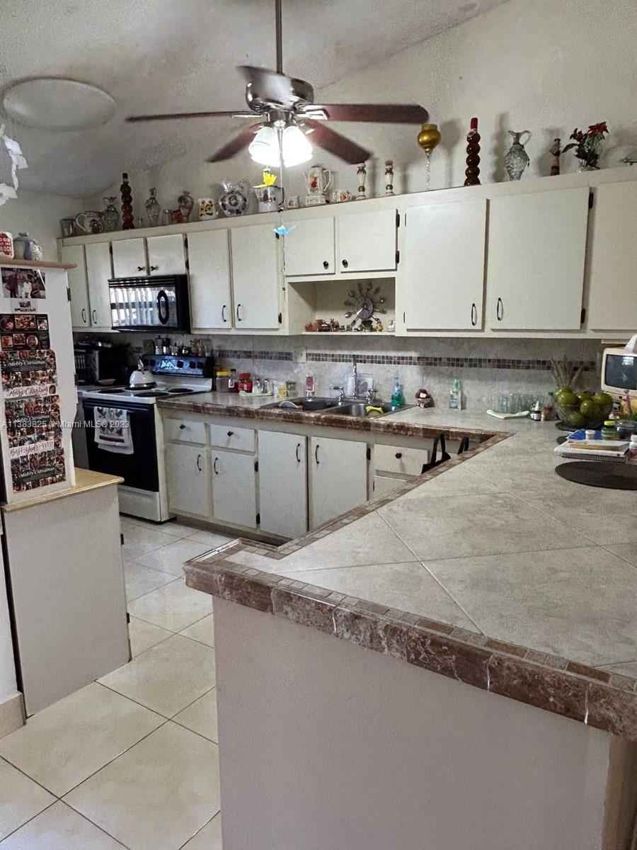 West End Miami, FL 33193 - Photo 2 of 5 a kitchen with stainless steel appliances granite countertop a sink a stove and cabinets