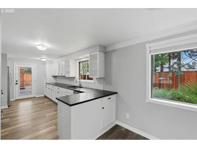a kitchen view with wooden floor and window