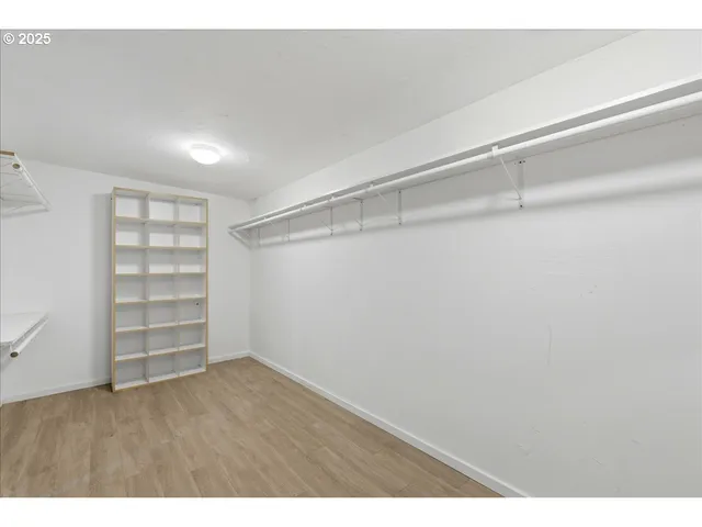 a view of walk in closet with empty racks