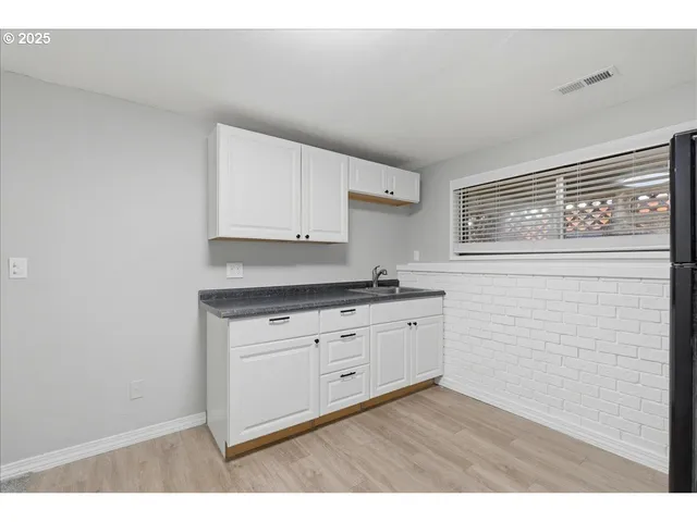 a kitchen with granite countertop white cabinets and white appliances