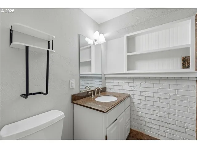 a bathroom with a sink a toilet and a mirror