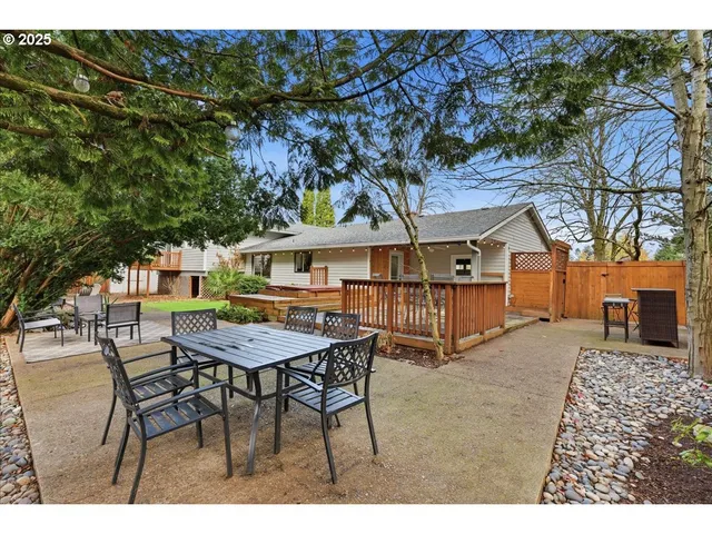 a view of a house with a table and chairs in a patio
