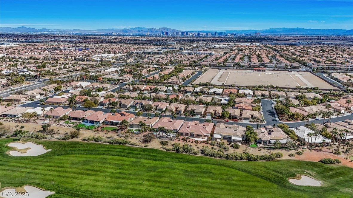 5015 Rivedro Street Las Vegas, NV 89135 - Photo 80 of 91 Soaring above a verdant golf course, this aerial view captures a sprawling residential community with mountain vistas.