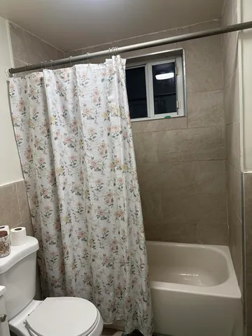 a bathroom with a toilet and a shower curtain