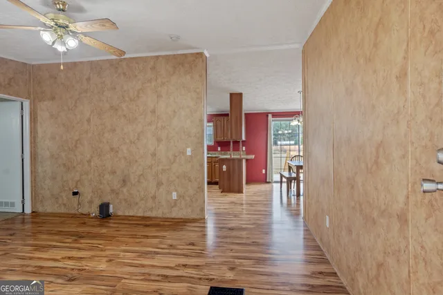 a view of a livingroom with wooden floor and ceiling fan