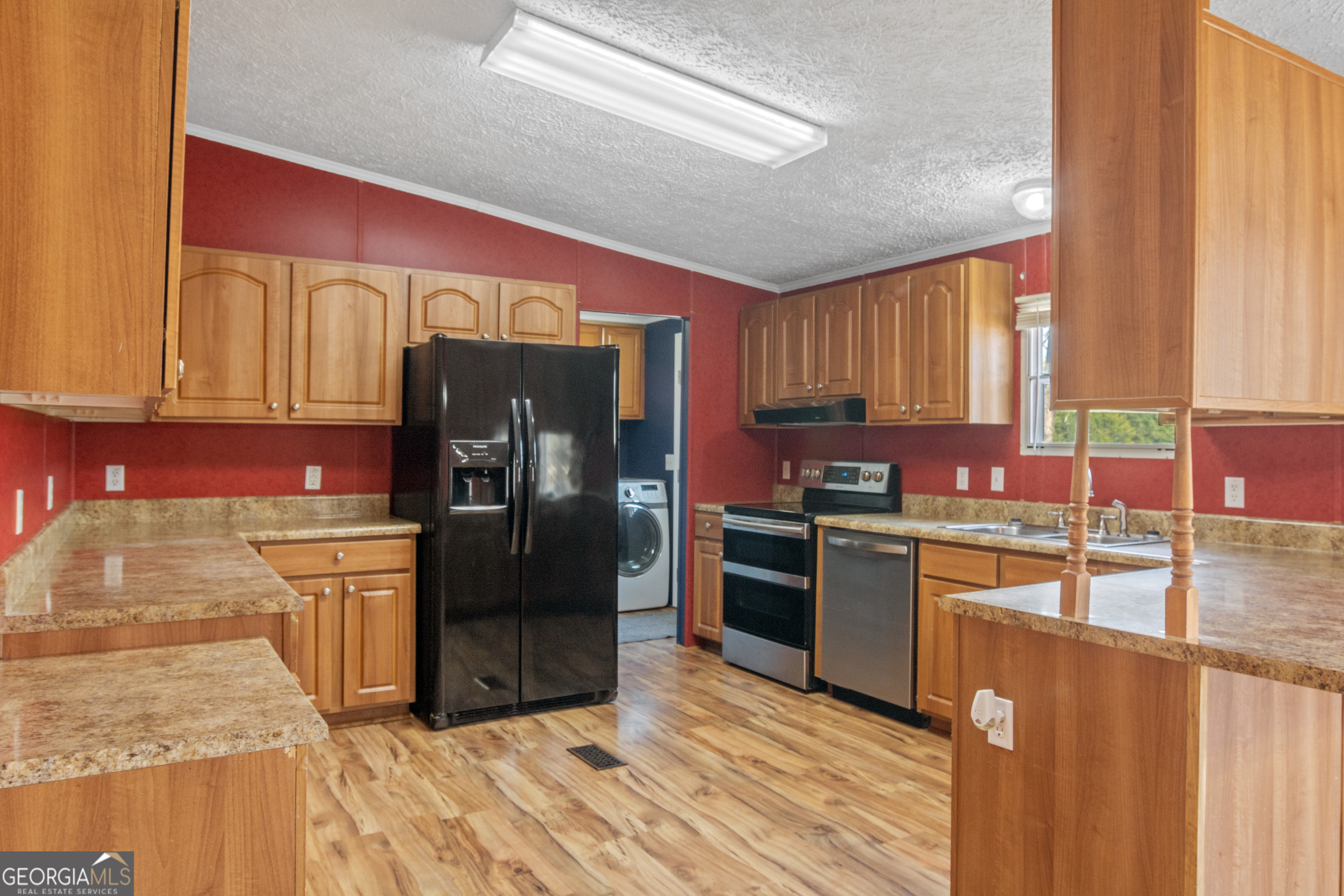 907 Sheppard Road Tennille, GA 31089 - Photo 16 of 54 a kitchen with granite countertop a refrigerator stove top oven and sink