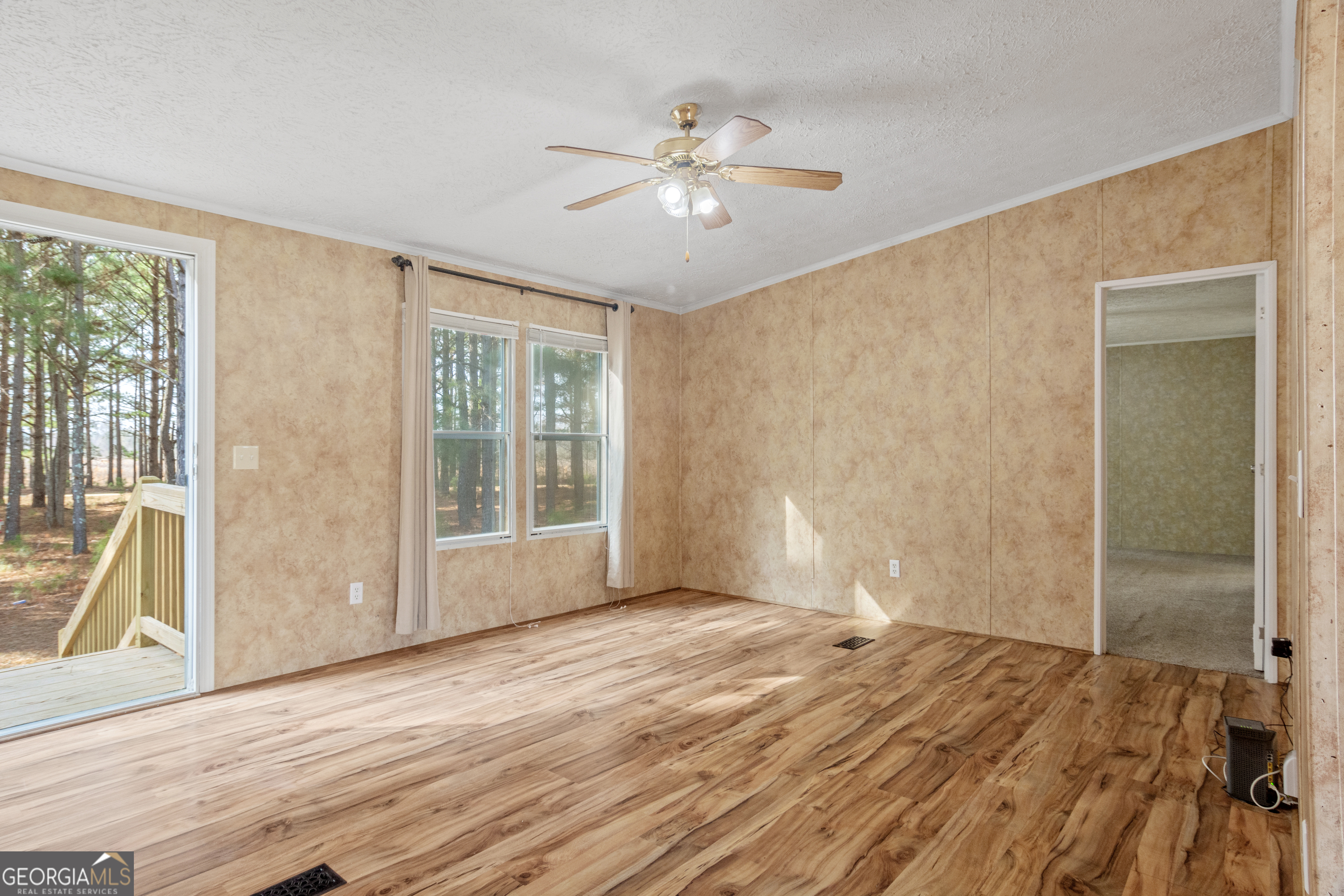 907 Sheppard Road Tennille, GA 31089 - Photo 20 of 54 a view of an empty room with wooden floor and a window