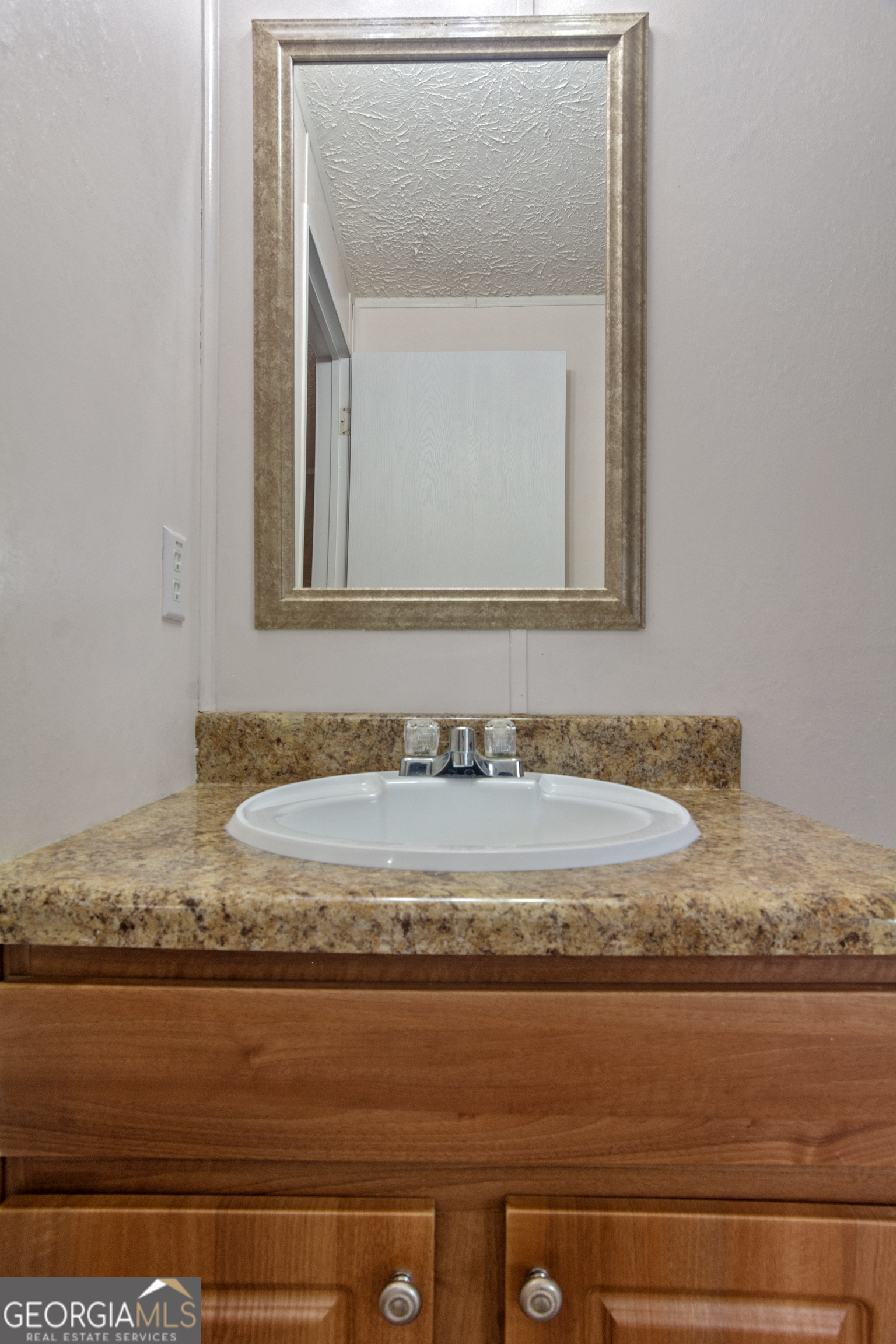 907 Sheppard Road Tennille, GA 31089 - Photo 33 of 54 a bathroom with a granite countertop sink and mirror