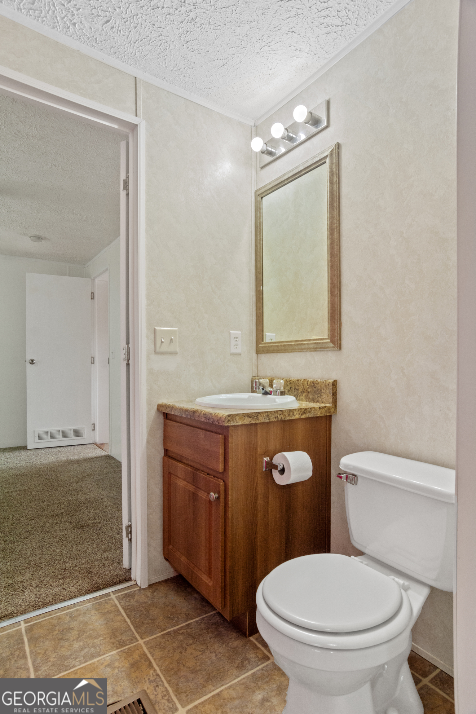 907 Sheppard Road Tennille, GA 31089 - Photo 40 of 54 a bathroom with a toilet sink vanity and mirror