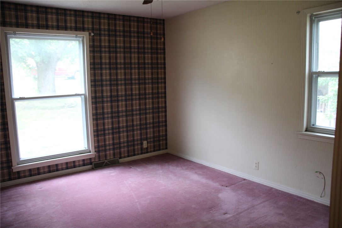 402 Canaan Road Marshall, AR 72650 - Photo 21 of 37 Room featuring two windows, one wall with plaid wallpaper, and three walls with a light-toned finish