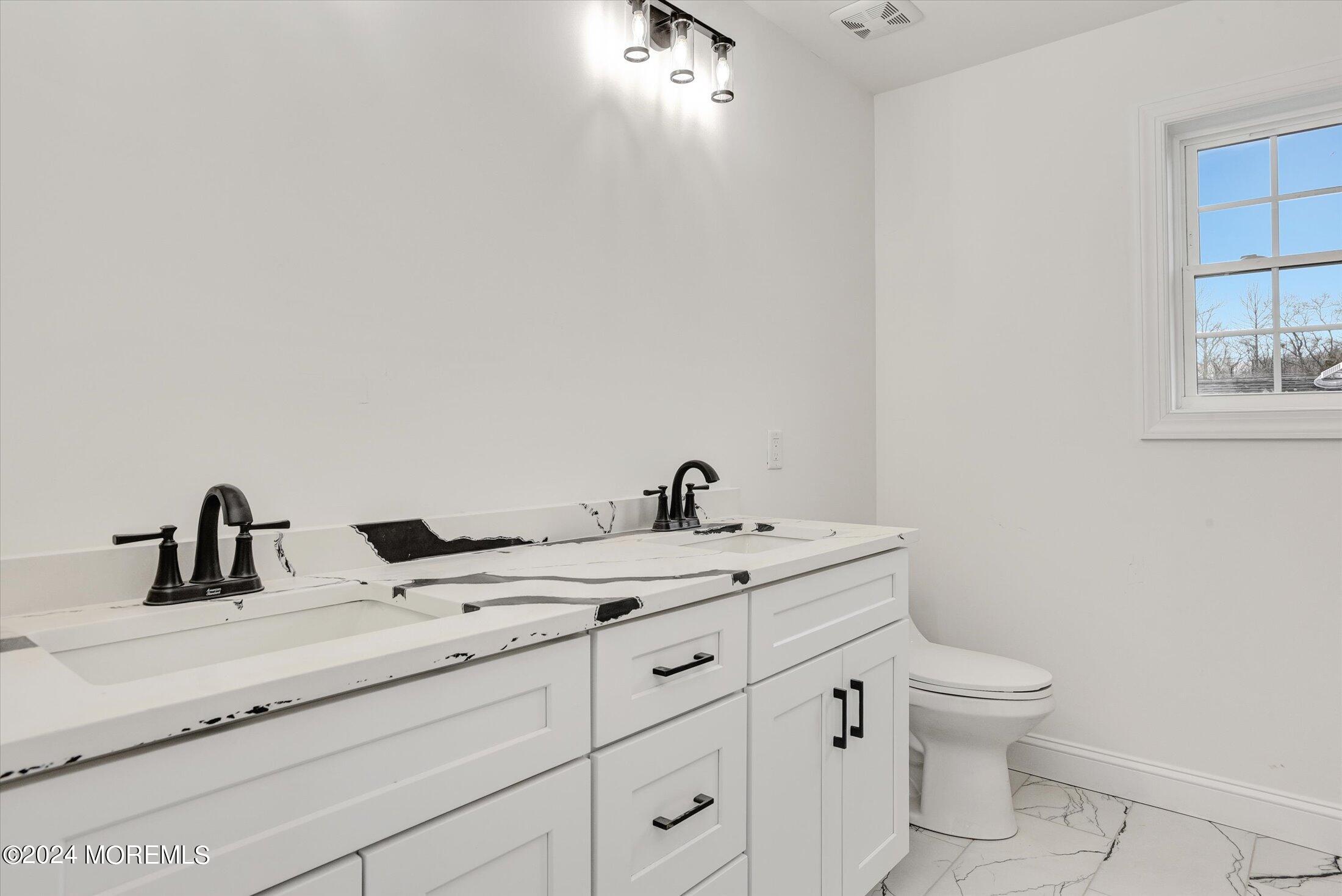 194 Texas Road Morganville, NJ 07751 - Photo 26 of 41 a bathroom with a toilet sink and mirror