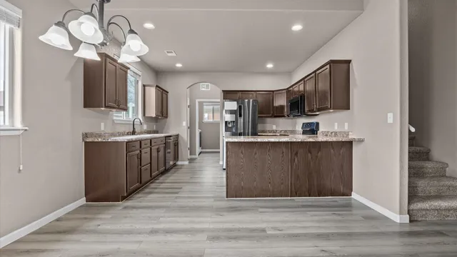 a large kitchen with kitchen island a island wooden cabinets and stainless steel appliances