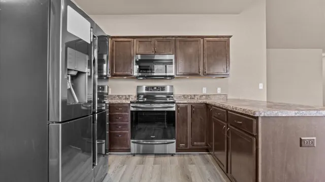 a kitchen with stainless steel appliances granite countertop a refrigerator stove and sink