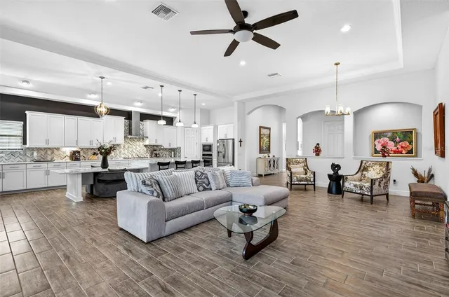 a kitchen with stainless steel appliances kitchen island granite countertop a table chairs sink and cabinets