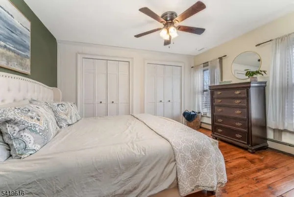 a bedroom with a bed a dresser and a chandelier