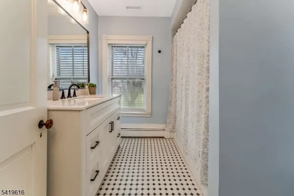 a bathroom with a sink a toilet a window and vanity