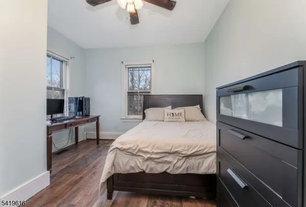 a bedroom with a bed and a flat tv screen on dresser