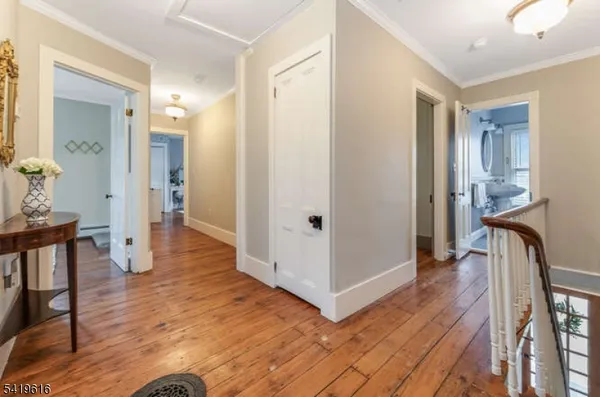 a view of a hallway with wooden floor and furniture