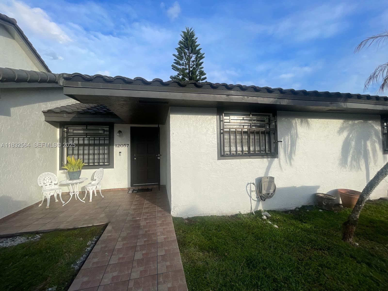 12057 Southwest 10th Street, Unit 202 Miami, FL 33184 - Photo 2 of 12 a front view of a house with a yard