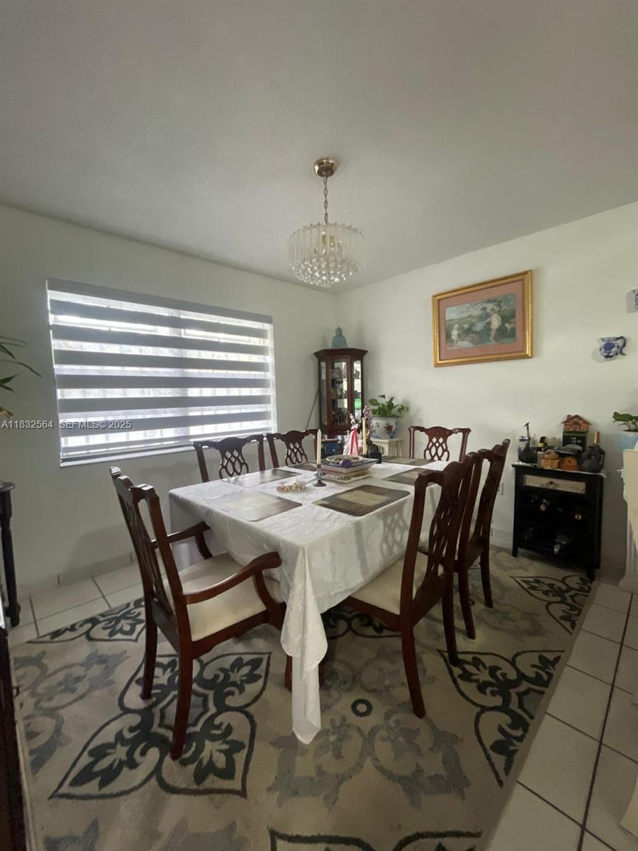 12057 Southwest 10th Street, Unit 202 Miami, FL 33184 - Photo 6 of 12 a view of a dining room with furniture and chandelier