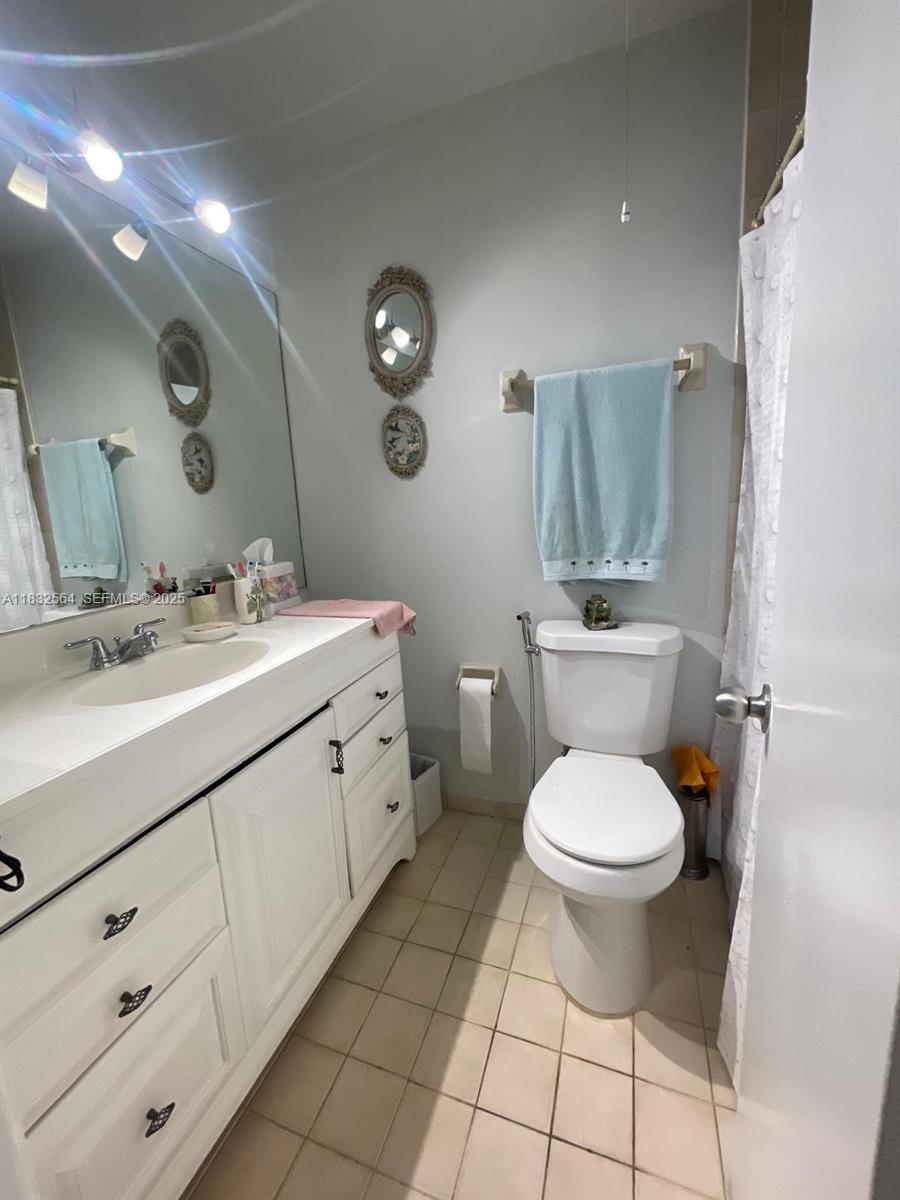 12057 Southwest 10th Street, Unit 202 Miami, FL 33184 - Photo 8 of 12 a bathroom with a toilet sink and mirror