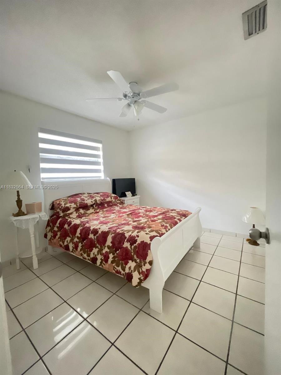 12057 Southwest 10th Street, Unit 202 Miami, FL 33184 - Photo 10 of 12 a bedroom with a bed and a table