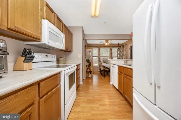 a kitchen with stainless steel appliances granite countertop lots of counter top space and wooden floor
